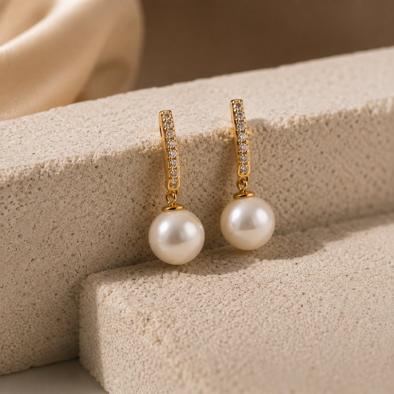 Pearl drop earrings on diamond-set gold hoops