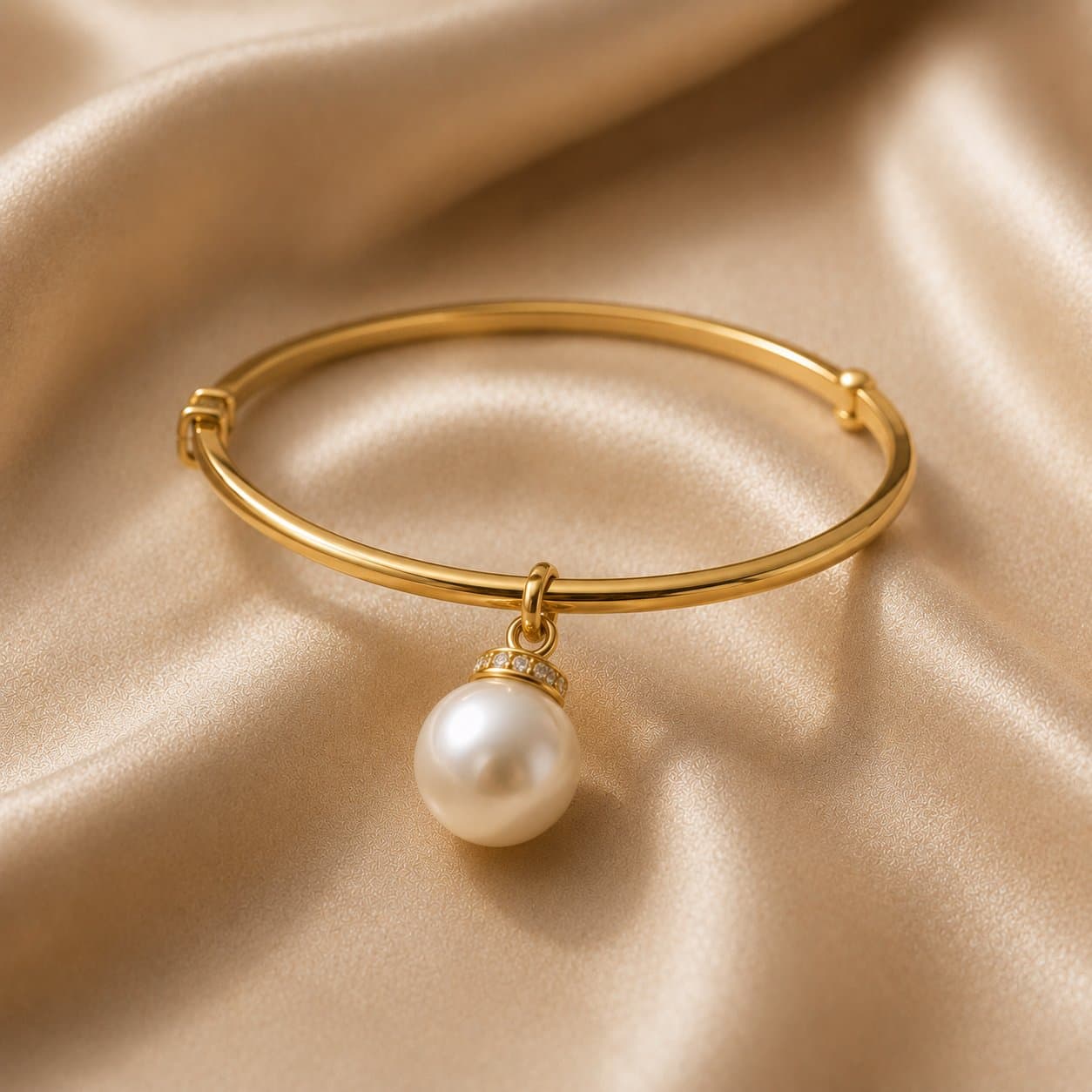 Gold bangle with a pearl and diamond charm